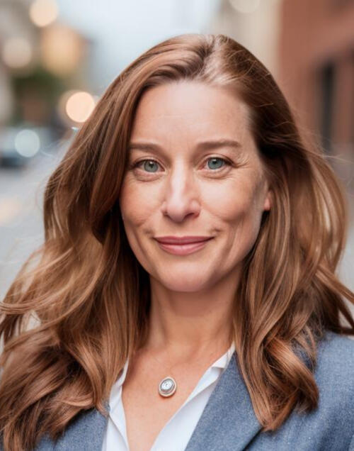 An image of Christine smiling toward the camera on a street in Lower Manhattan